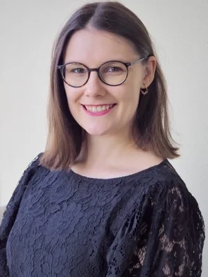 Eine Wissenschaftlerin und ein Wissenschaftler arbeiten hinter einer Glasfassade und mischen Chemikalien mit Großgeräten.